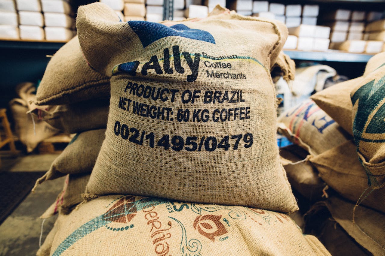 Stack of Brazilian coffee bags in a warehouse, highlighting global trade and commerce.